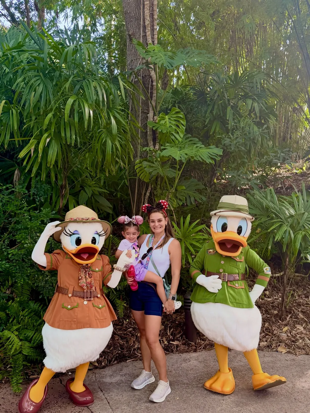 Lore com a filha no colo posando entre o Pato Donald e a Margarida no Animal Kingdom, em Orlando